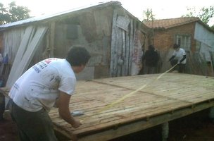 Voluntarios ubican los paneles antes de iniciarse otra jornada de construcción